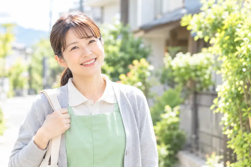 住宅街でほほえむ訪問介護員